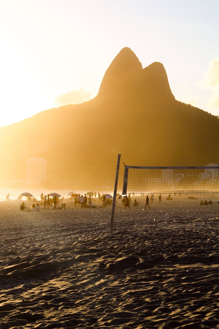 A scenic view of Ipanema Beach at sunset with the iconic Two Brothers Mountain in Rio de Janeiro, Brazil.